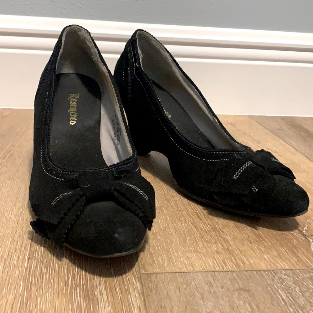 Restricted black heels, white stitching. Bow accent. Sz 8.